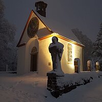 Gertrudis-Kapelle im Schnee, bei Nacht, angestrahlt.
