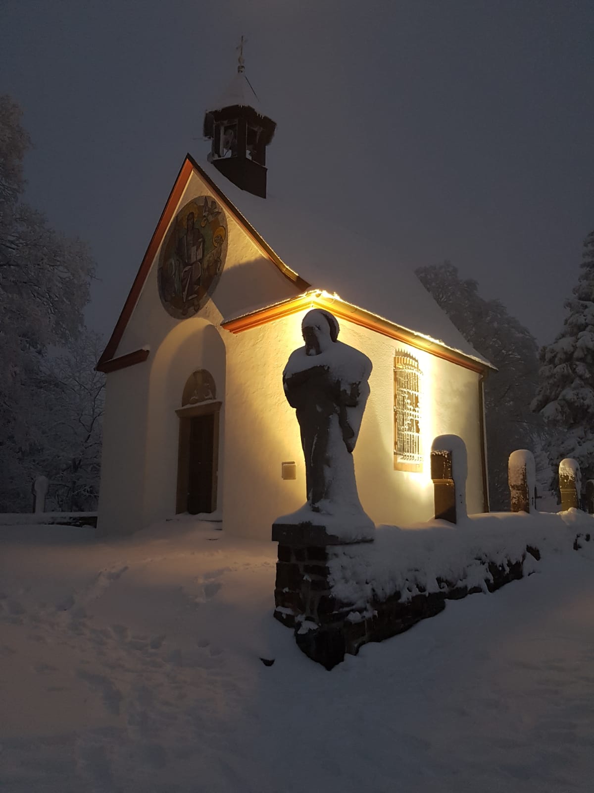 Gertrudis-Kapelle im Schnee, bei Nacht, angestrahlt.